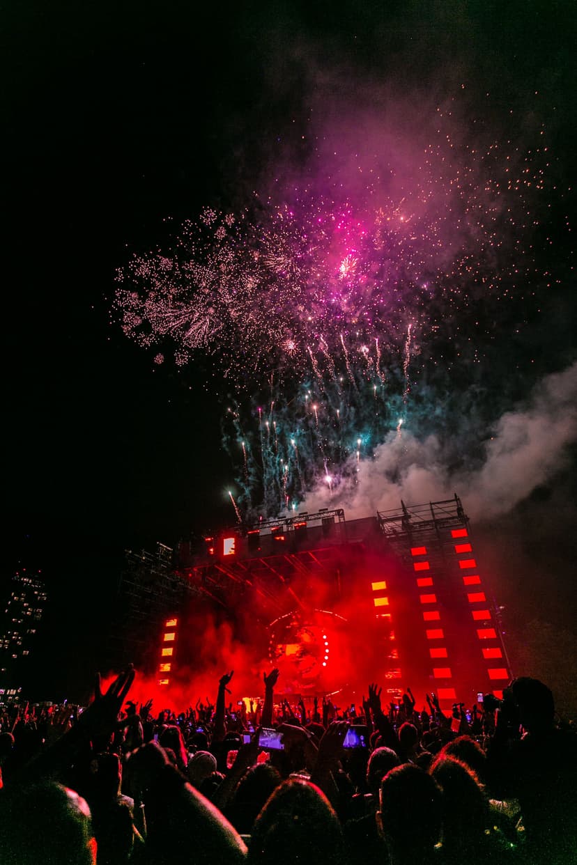 Professional DJ performing at turntables with colorful stage lighting