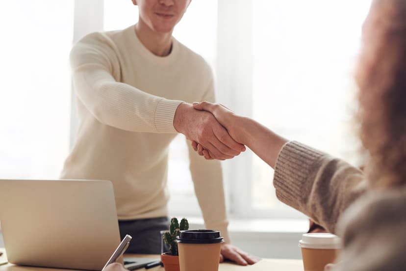 Professional business handshake over a signed contract on a desk